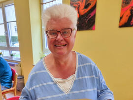 Eine Frau hält einen selbstgebackenen Kuchen in der Hand.