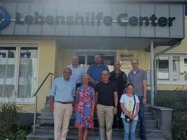 Mehrere Personen stehen mit Herrn Scharzkopf vor dem Lebenshilfe Center.