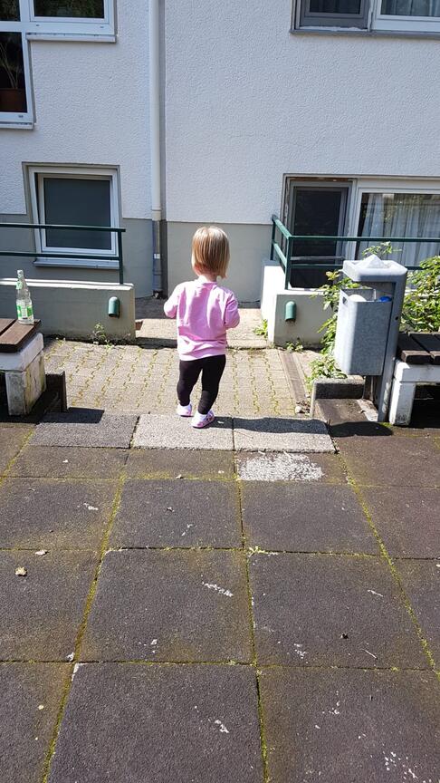Kind von hinten geht Stufe hinunter