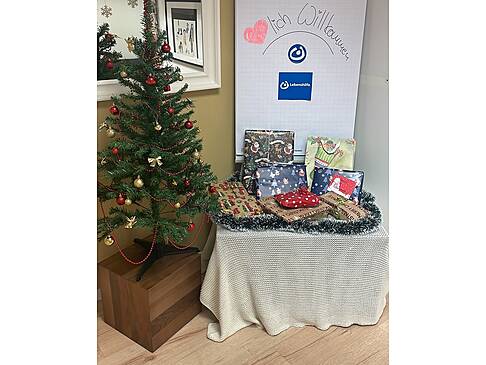 Ein Weihnachtsbaum und daneben steht ein Tisch mit Geschenken