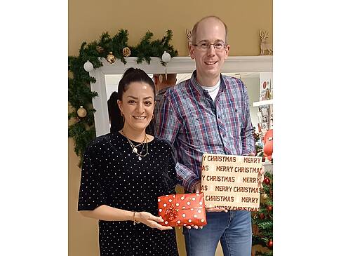 Ein Mann und eine Frau mit Geschenken in der Hand.
