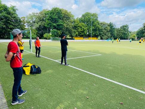 Personen am Spielfeldrand.