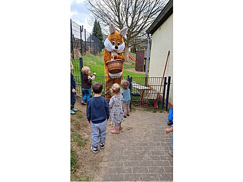 Der Hase schenkt den Kindern etwas.