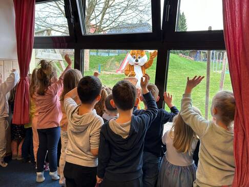 Viele Kinder winken dem Hasen zu.