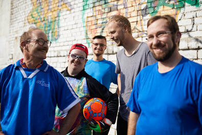 Mehrere Männer im Trikot, einer hat einen Fussball in der Hand.
