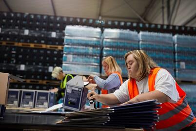 Eine Frau mit einer Warnweste bei der Arbeit.