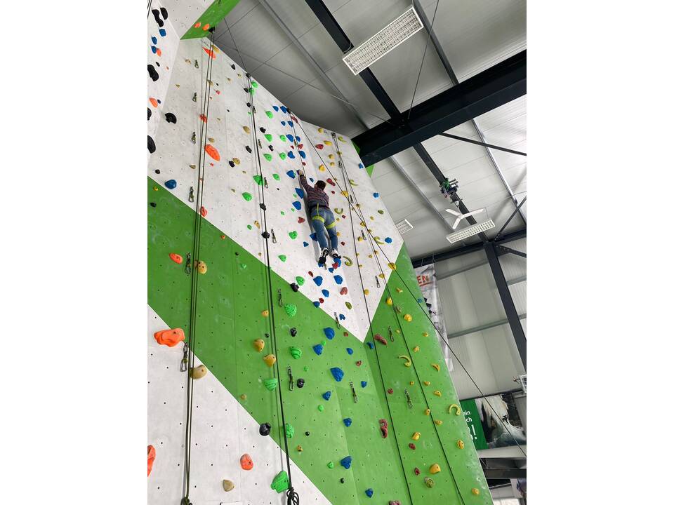 Ein junger Mensch klettern an einer Kletterwand