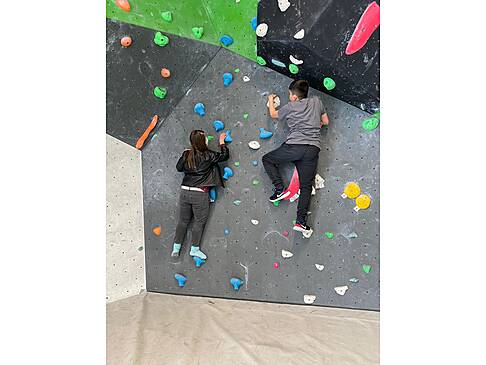 Zwei junge Menschen an der Kletterwand