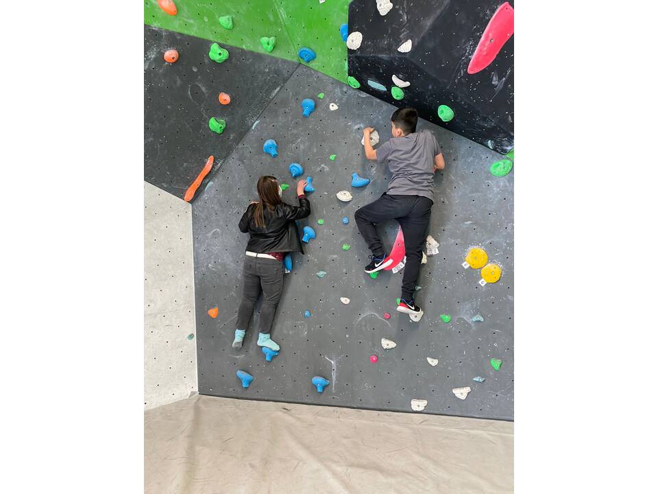 Zwei junge Menschen an der Kletterwand