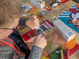 Eine Person bastelt an einem Tisch mit neuen Materialien.