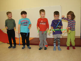 Fünf Kinder stehen in einer Reihge und spielen