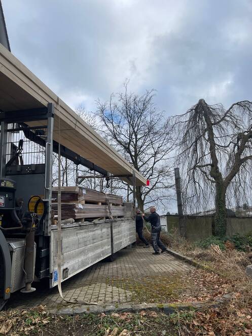 Ein LKW mit Materialien wird abgeladen.