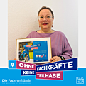 Eine Frau mit einem Schild Ohne Fachkräfte keine Teilhabe