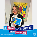 Eine Frau mit einem Schild Ohne Fachkräfte keine Teilhabe