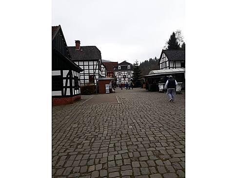 Ein großer gepflasteter Platz mit Fachwerkhäusern.