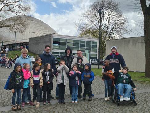 Bild zehn zeigt ein Gruppe Kinder und Erwachsene