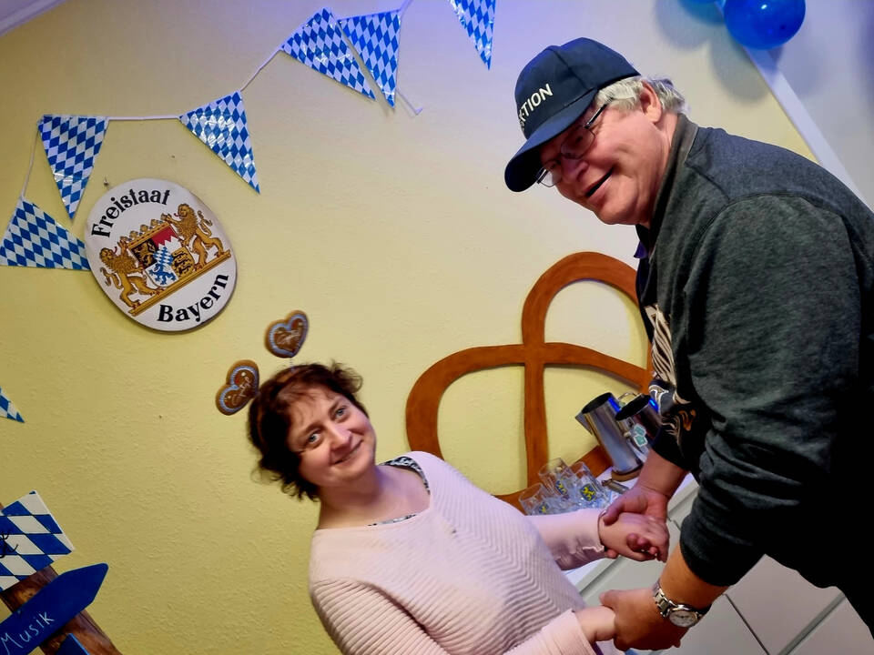 Ein Mann und eine Frau halten sich an den Händen und lächeln.