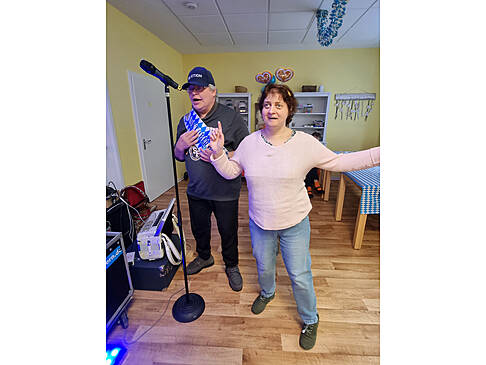 Ein Mann und eine Frau stehen in einem Raum und singen.