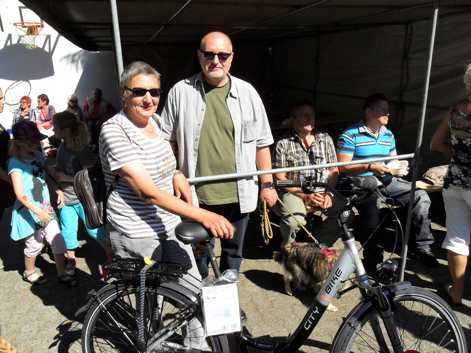 Eine Frau und ein Mann neben einem Fahrrad.