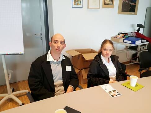 Ein Mann und eine Frau sitzen an einem Tisch.