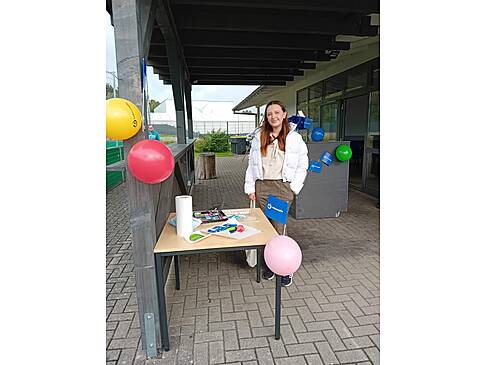 Eine Frau steht an einem Infostand.
