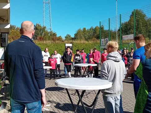 Viele Personen stehen draussen in der Sonne.
