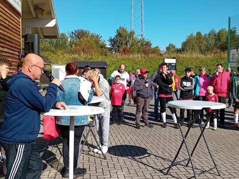 Viele Personen stehen draussen in der Sonne.
