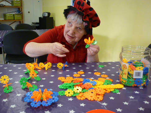 Eine Frau steckt bunte Kunststoffteile zusammen.