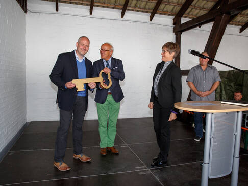Zwei Männer mit goldenem Schlüssel in der Hand.