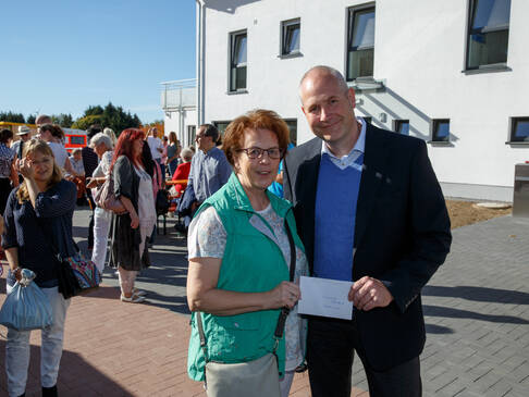 Mann und Frau mit Scheck in der Hand.
