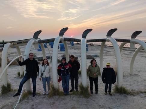 Gruppenfoto am Strand an einem Gebilde.