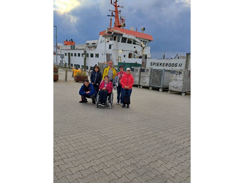 Gruppenfoto vor einem Schiff.