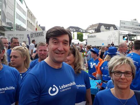 Mehrere Personen mit Lebenshilfe T-Shirts in der Mitte Herr Bachmann.
