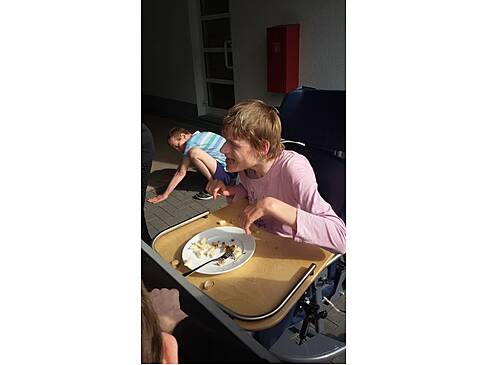 Eine Frau im Rollstuhl ist fertig mit essen.
