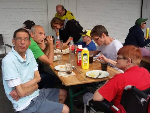 Mehrere Personen sitzen am Tisch und essen.