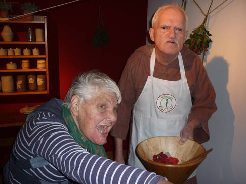 Eine Frau und ein Mann, er hat eine Schürze an und eine Schale in der Hand.