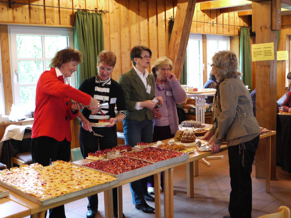 Mehrere Personen stehen am Kuchenbuffet.