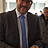 Ein Mann hat ein Buch vor sich und einen Stift in der Hand.