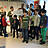 Mehrere Kinder stehen mit drei Erwachsenen in einem Raum und haben einen Scheck.