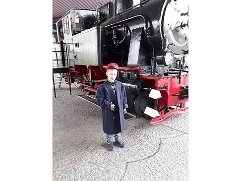 Eine Junge vor einer Dampflock.