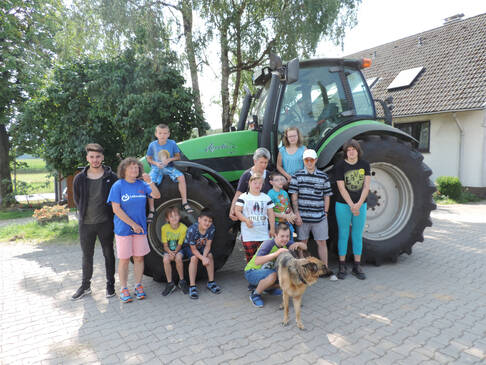 Kinder und Jugendliche vor einem Trecker.