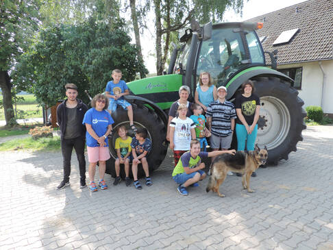 Kinder und Jugendliche vor einem Trecker.