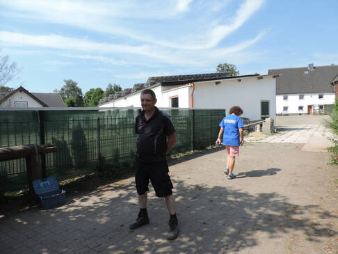 Zwei Personen draussen, eine geht weg.