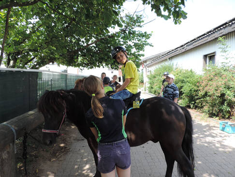 Ein Kind sitzt auf einem Pferd.