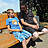 Ein Junge und ein Mann sitzen auf einer Bank in der Sonne.