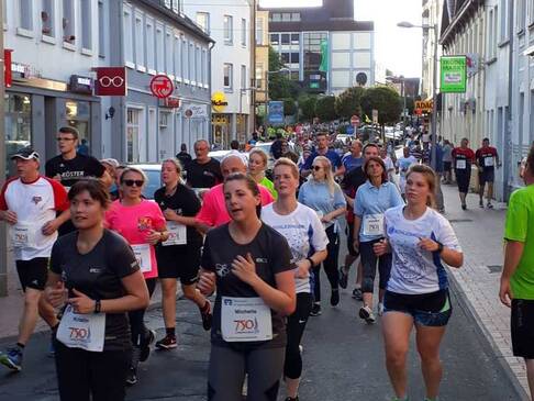 Viele Personen laufen über die Straße
