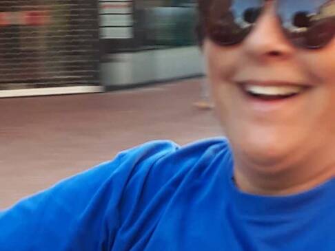 Eine Person mit Sonnenbrille lacht.