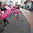 Zwei Persosonen mit Flamingoschwimmreifen laufenüber die Straße.