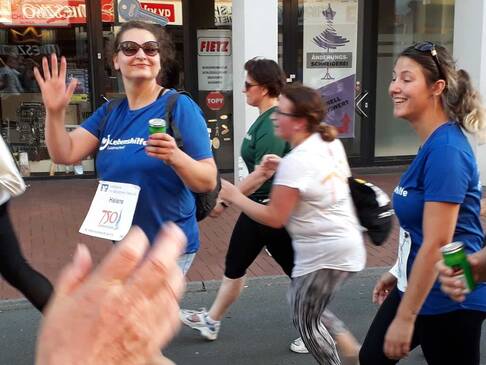 Zwei Frauen mit Lebenshilfe TShirts gehen und lächeln.