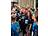 Eine Gruppe von Läuferinnen und Läufern in dunkelblauen „Never Walk Alone"-Shirts feiert ausgelassen in einer Fußgängerzone. Eine Person mit rotem Haar und Startnummer 356 reißt jubelnd die Arme hoch.